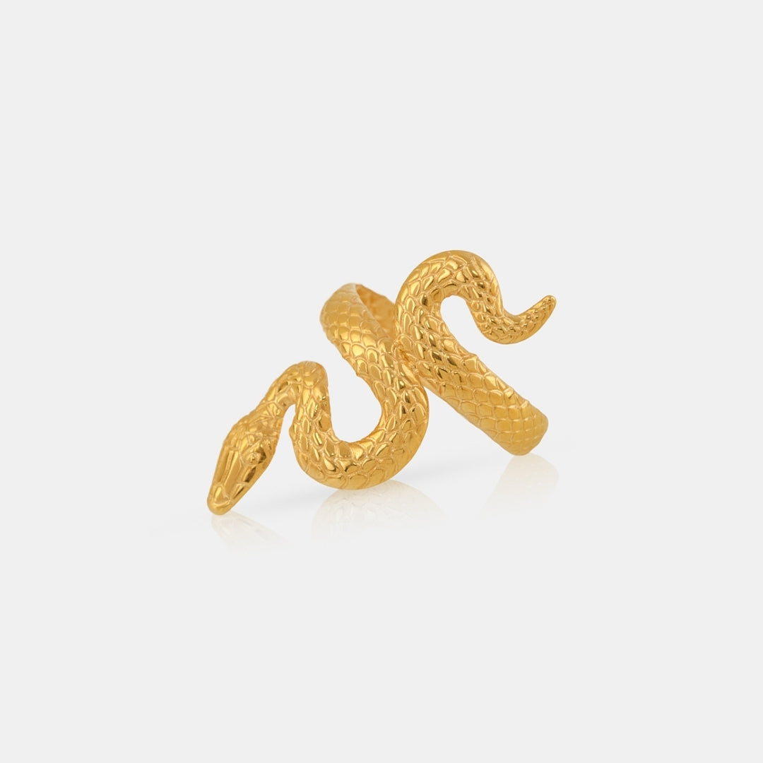 Gold snake-shaped ring on a light gray background