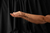 Hands with gold jewelry on a black background